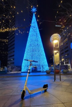 OKAI-Neon-ES20-with-a-Christmas-Tree-and-lights-on-with-solid-tire-large-deck-bell-rear-suspension-bright