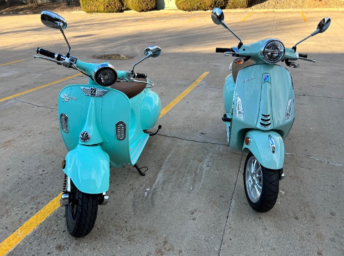 Aventura-X-Electric-Scooter-next-to-a-Vespa-50cc-Primavera